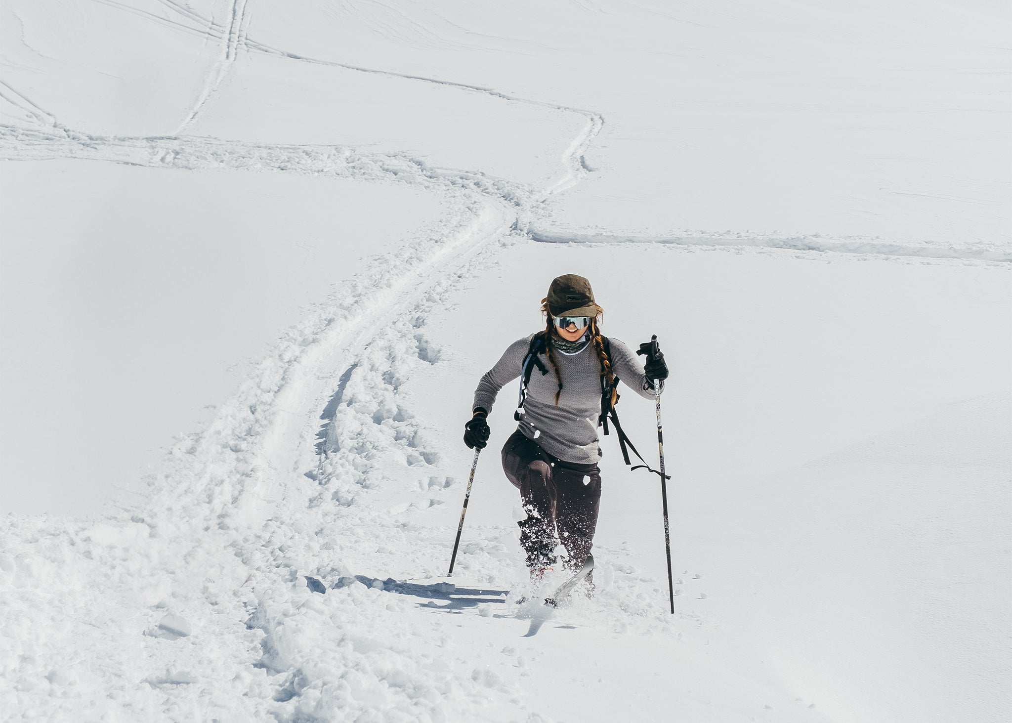woman trekking in deep snow in the backcountry mountains