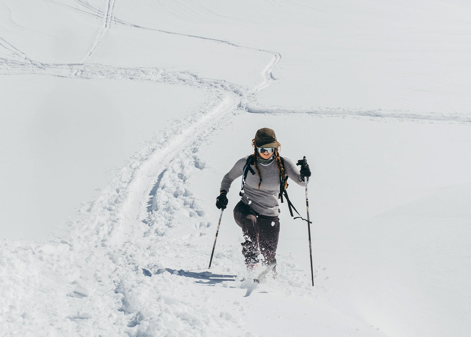 woman trekking in deep snow in the backcountry mountains