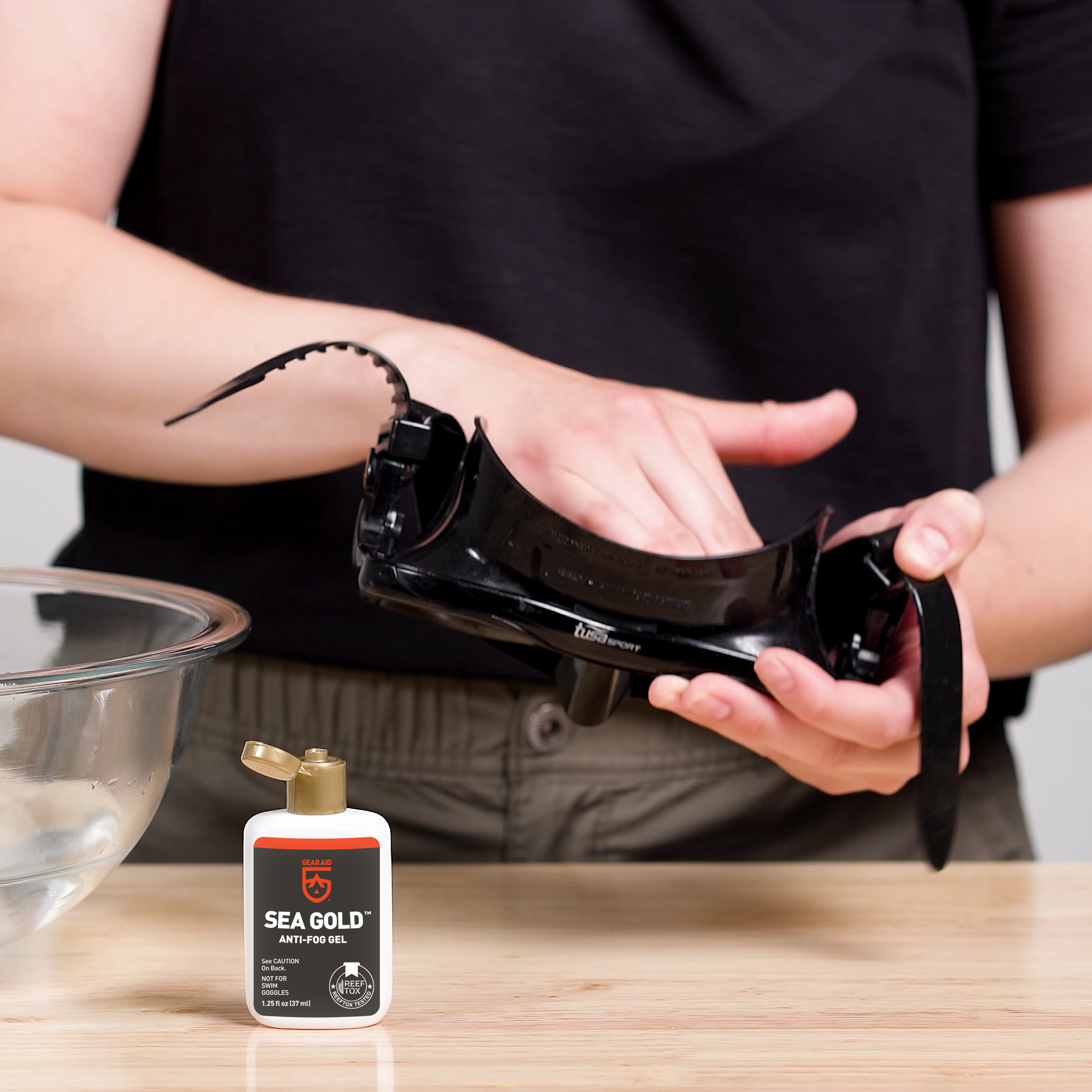 Applying GEAR AID Sea Gold Anti-Fog Gel to the inside lens of a dive mask