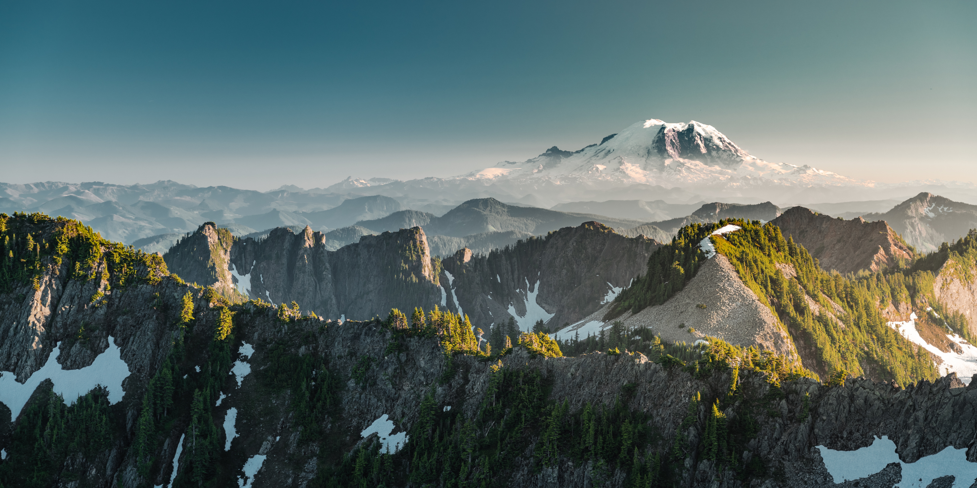Mountain range with snow-capped peaks under a clear blue sky