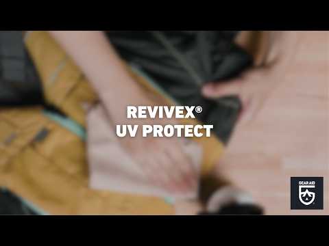Blurred video cover showing hands applying protectant to outdoor gear fabric on a tabletop, with the title “REVIVEX® UV PROTECT” centered and the Gear Aid logo in the bottom-right corner.