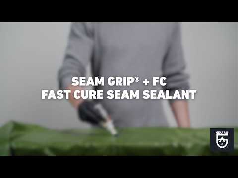 Blurred video cover showing a gloved hand applying seam sealant to green outdoor fabric, with the title “SEAM GRIP® + FC FAST CURE SEAM SEALANT” centered and the Gear Aid logo in the bottom-right corner.