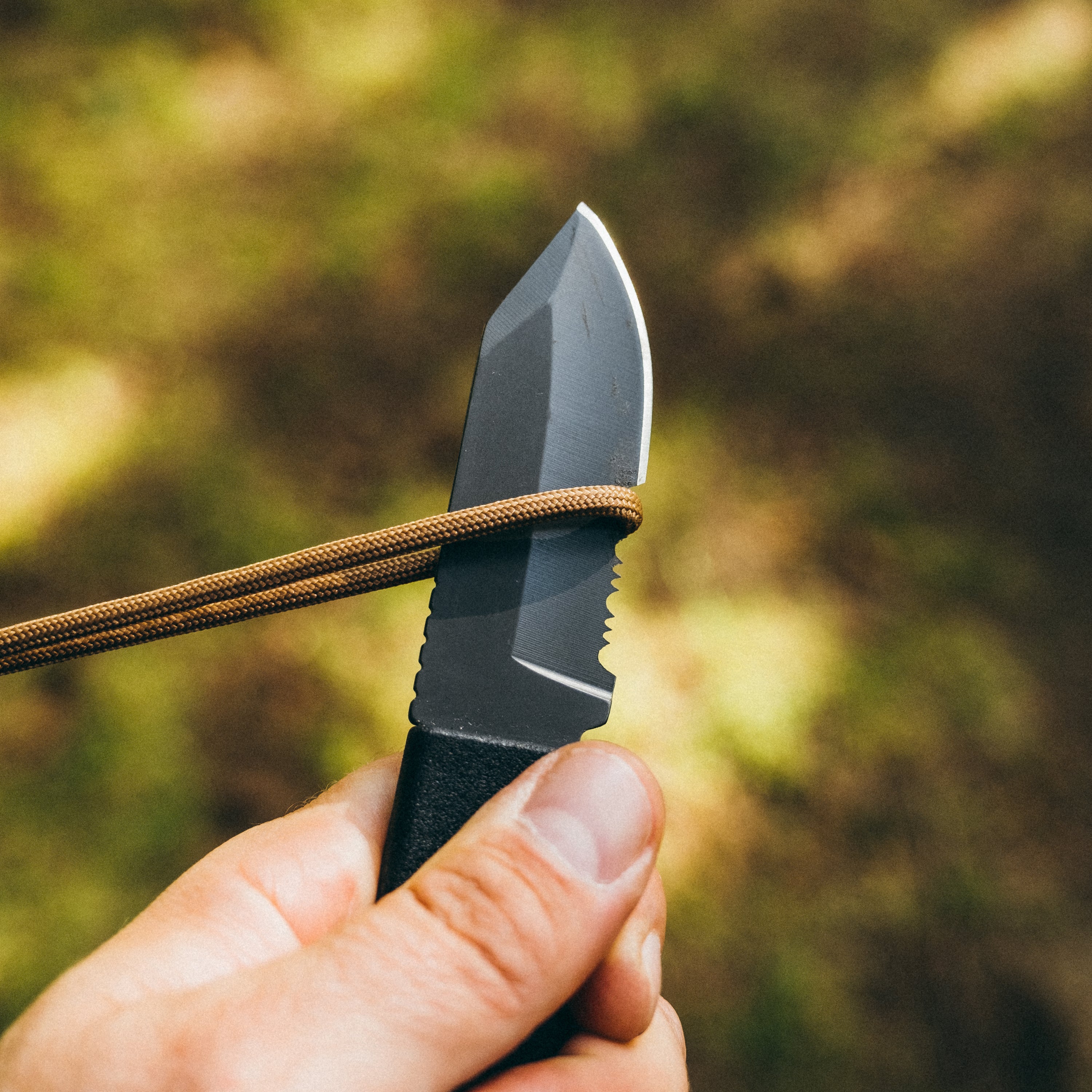 Hands holding a utility knife and slicing into a piece of Fire Strand, dappled light on green foliage in the background