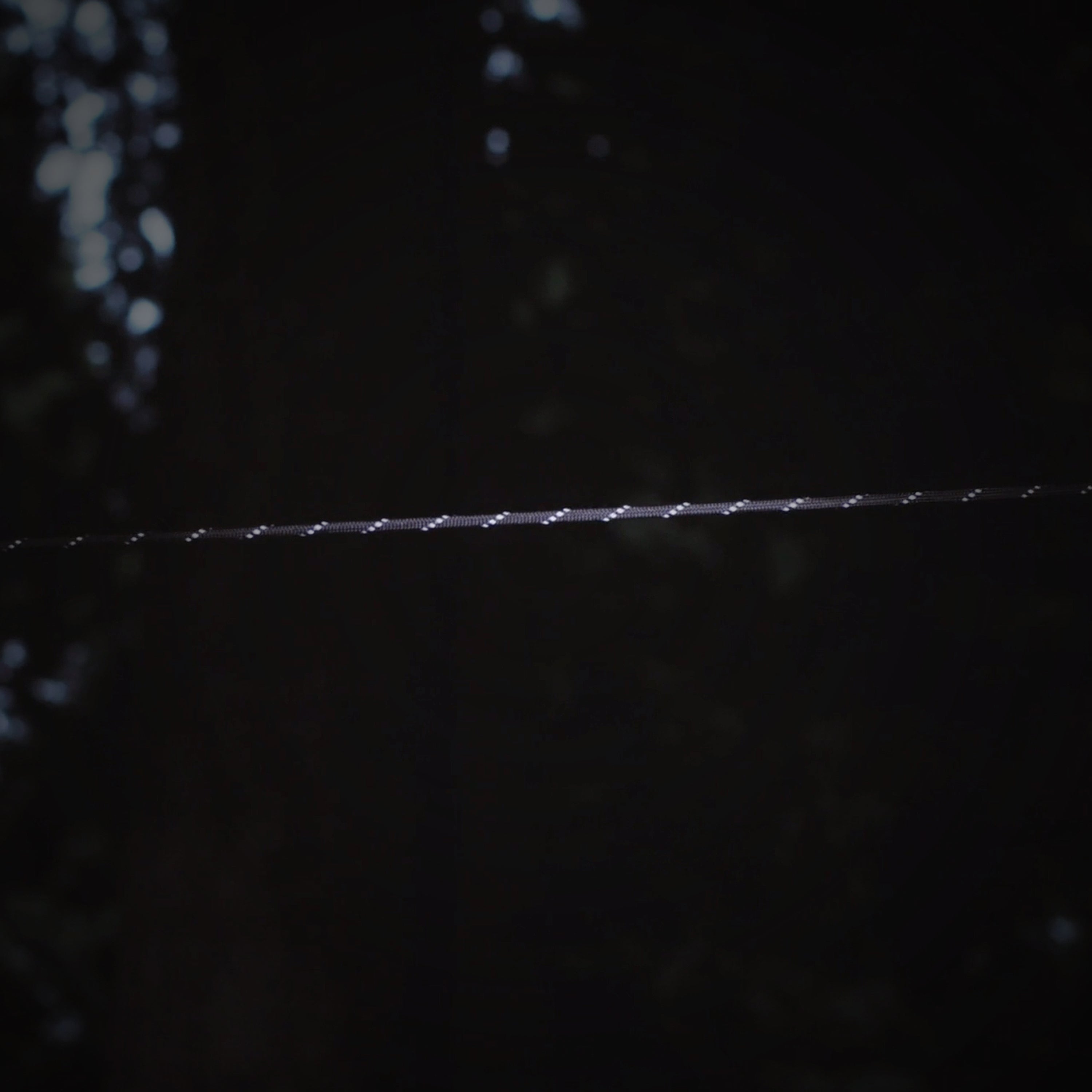 Dark image of Paracord in black reflective color reflecting some light at night