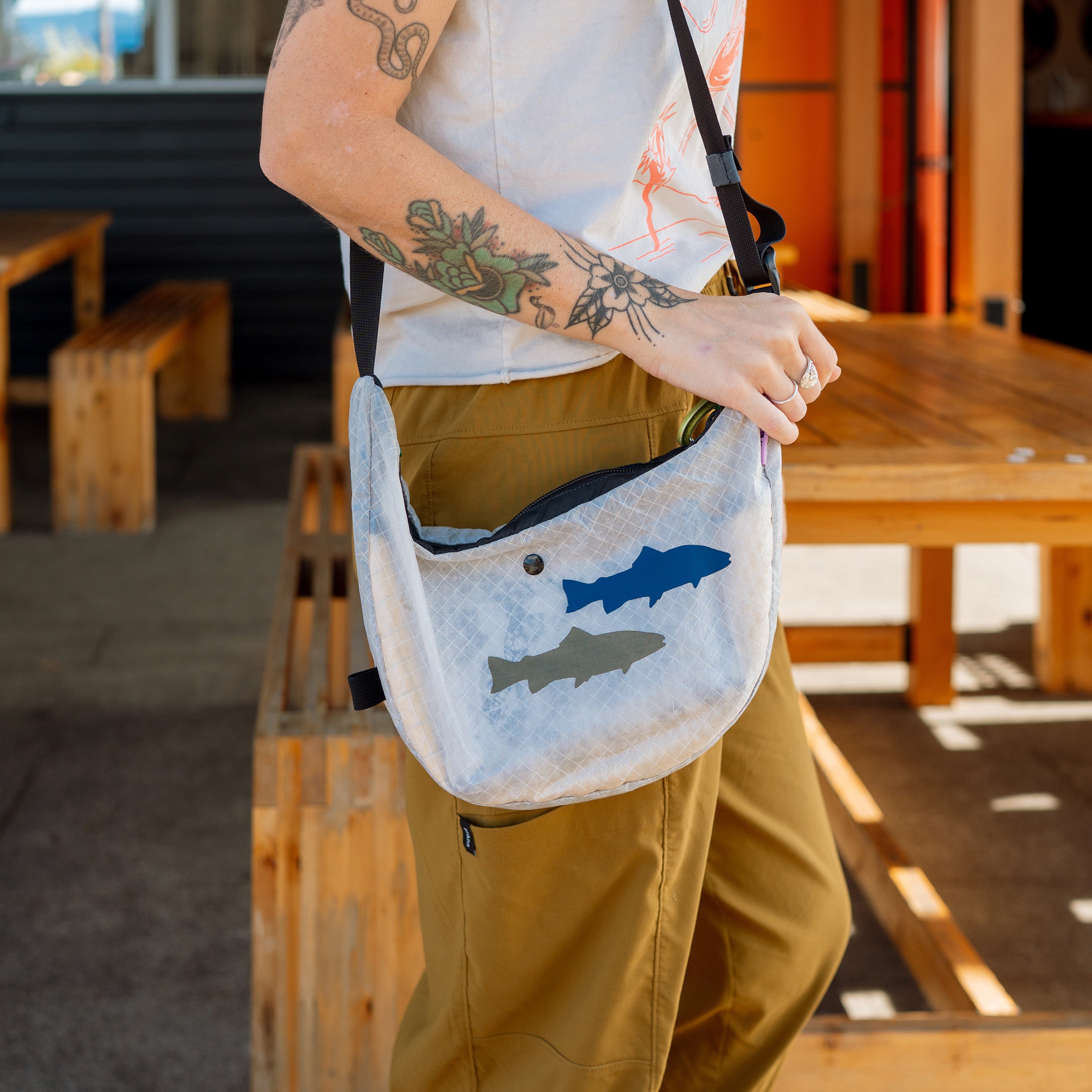 Person holding a white bag with fish patches in an outdoor setting