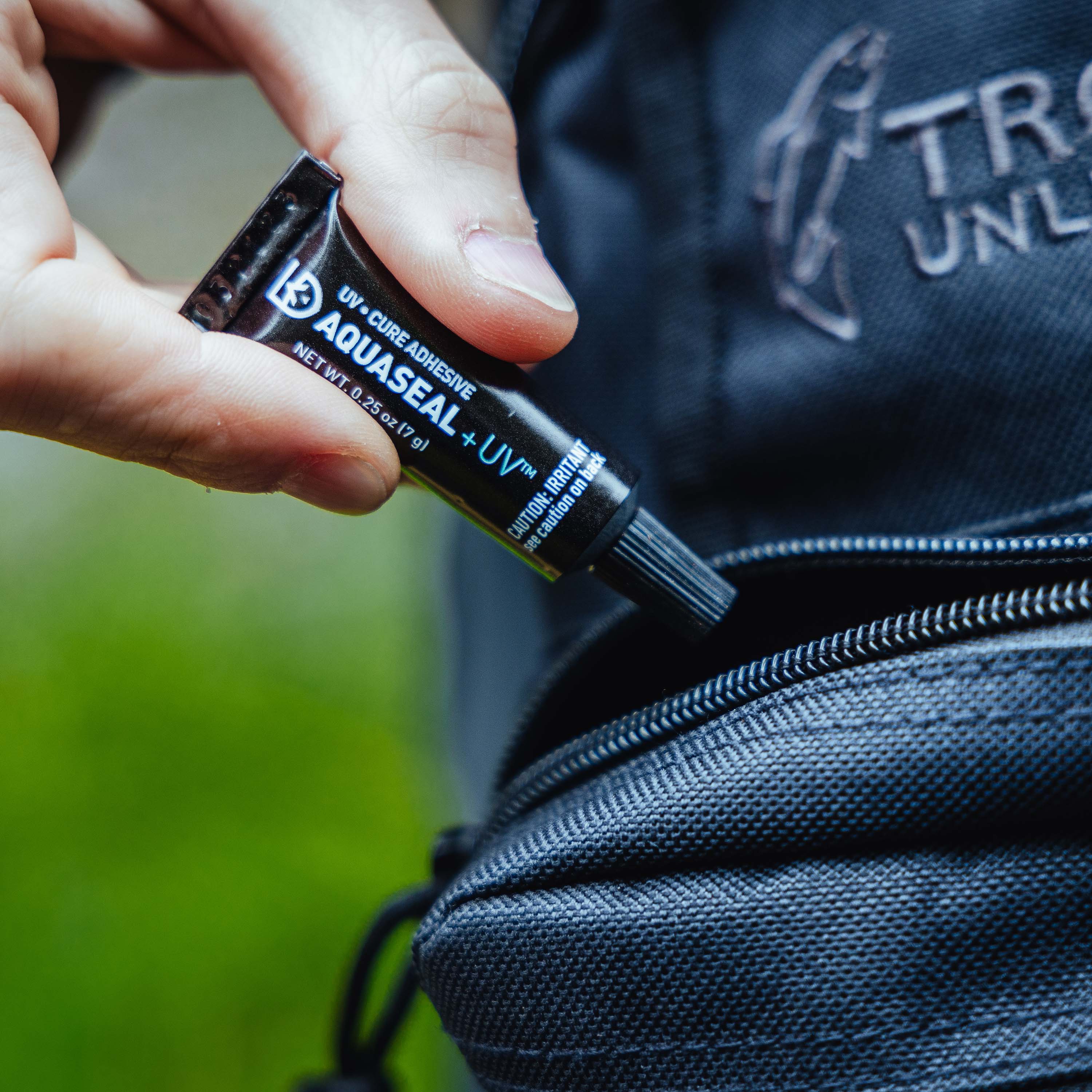 Close up of a person putting a tube of Aquaseal UV into a small bag