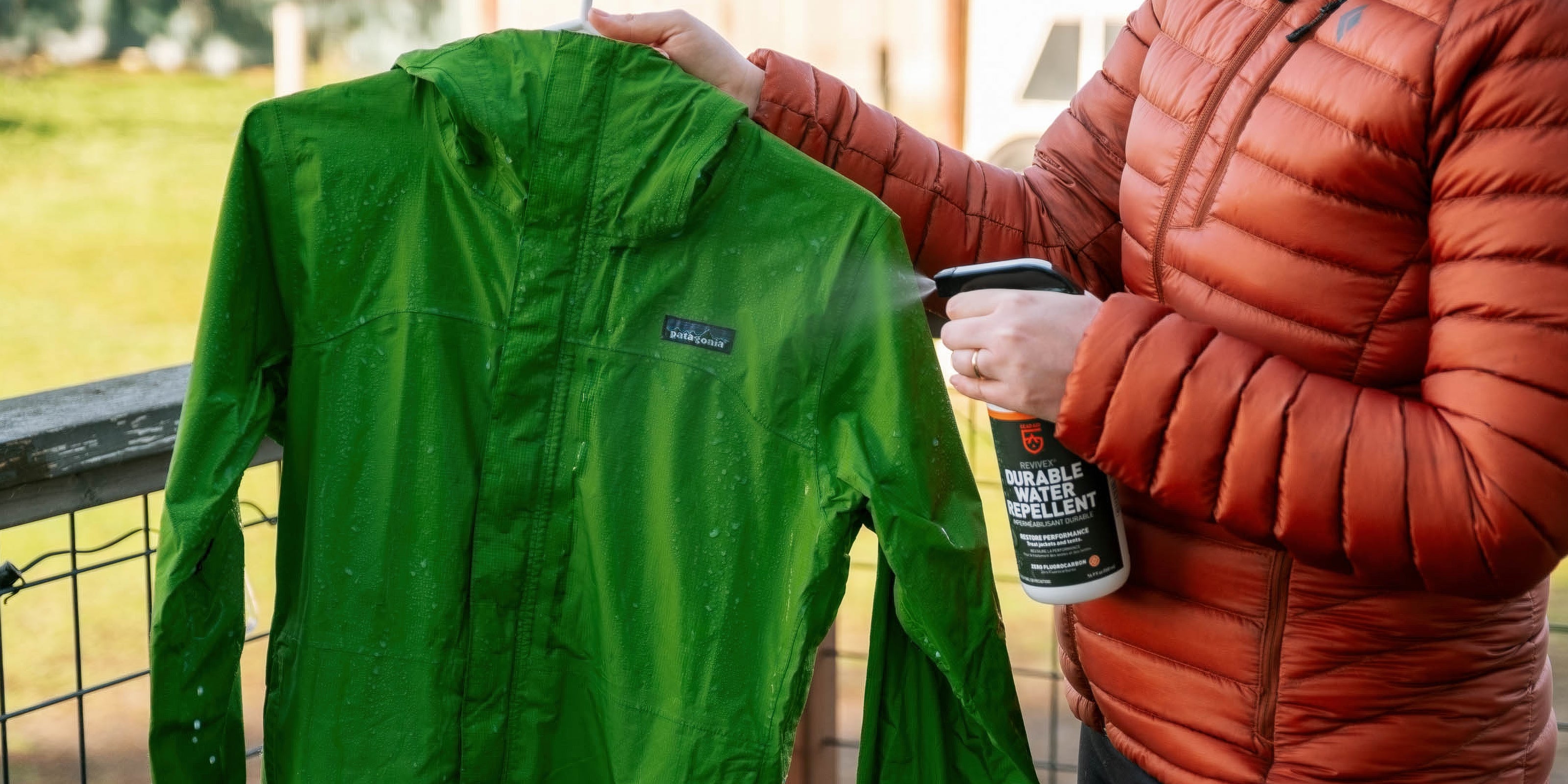 Person applying Durable Water Repellent spray to a green jacket