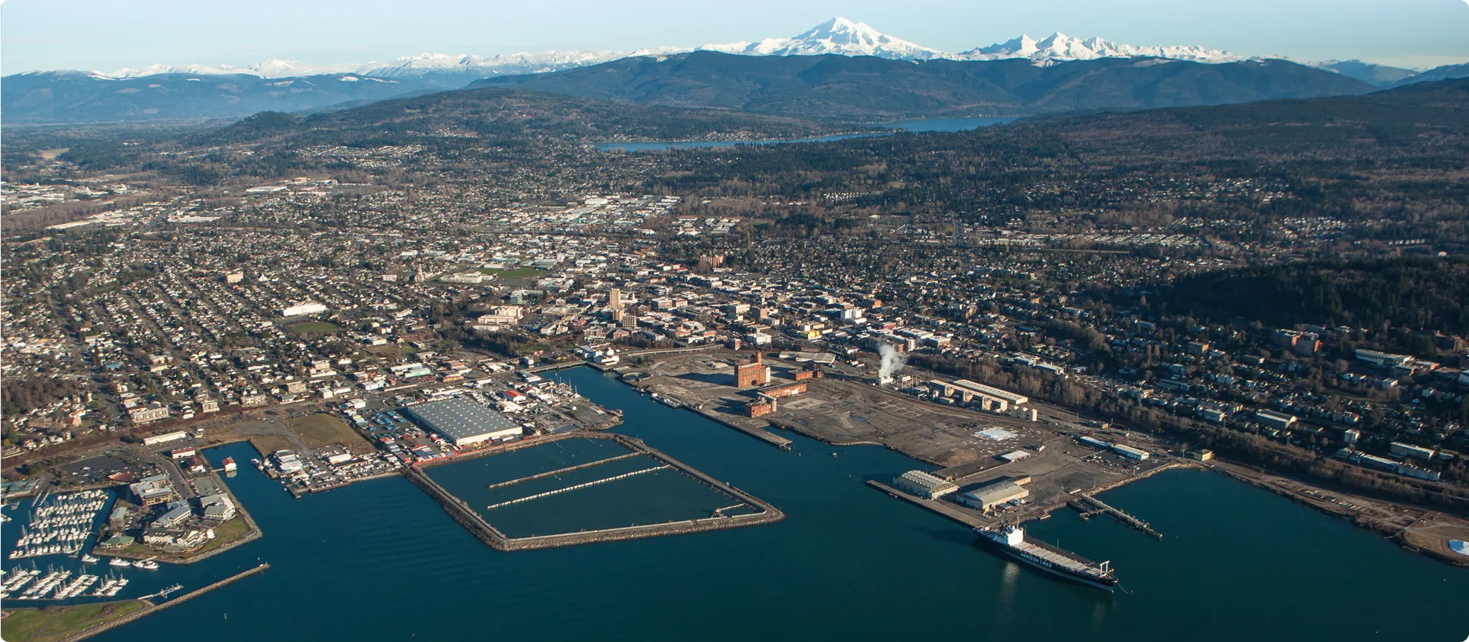 Aerial view of a coastal city with mountains in the background