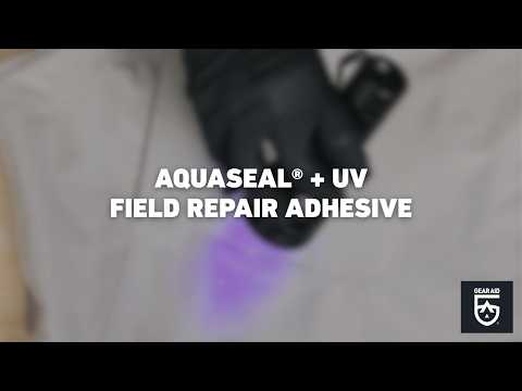 Blurred video cover showing a gloved hand using a UV light on light-colored fabric, with the title “AQUASEAL® + UV FIELD REPAIR ADHESIVE” centered and the Gear Aid logo in the bottom-right corner.