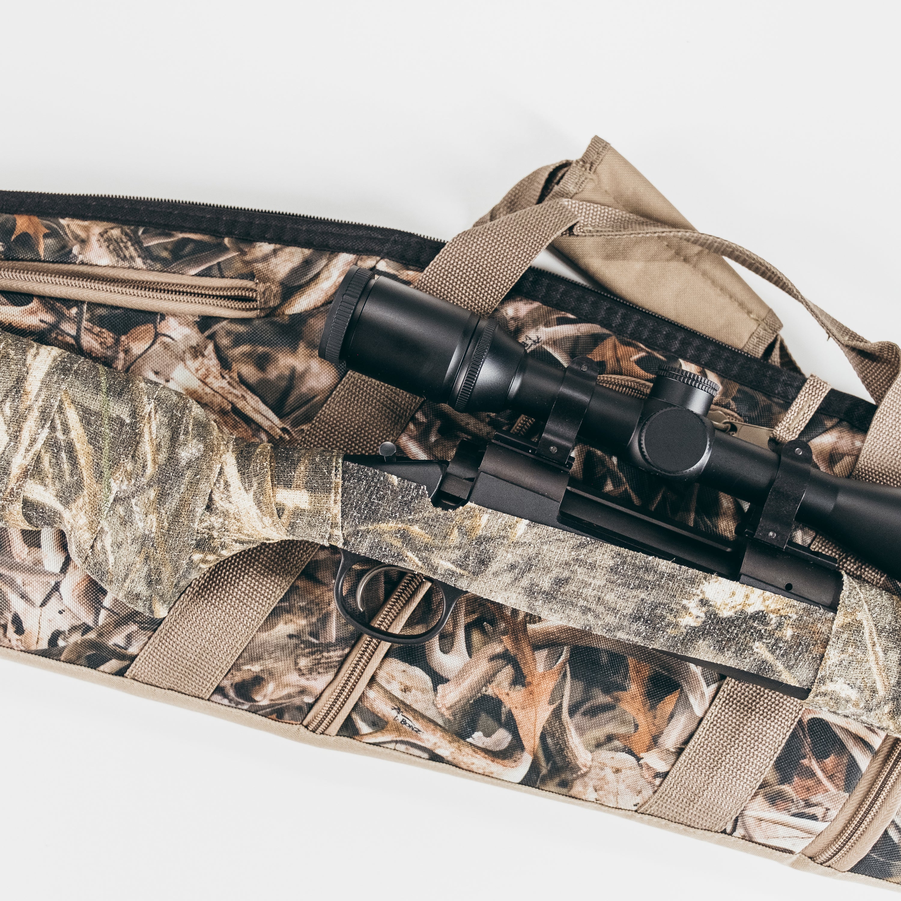 Camo form wrapped hunting gear sitting on camo bag on a white background